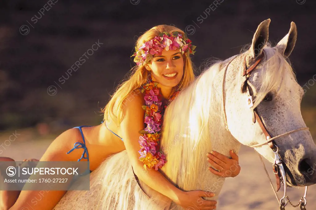 Blonde woman in bikini on horseback