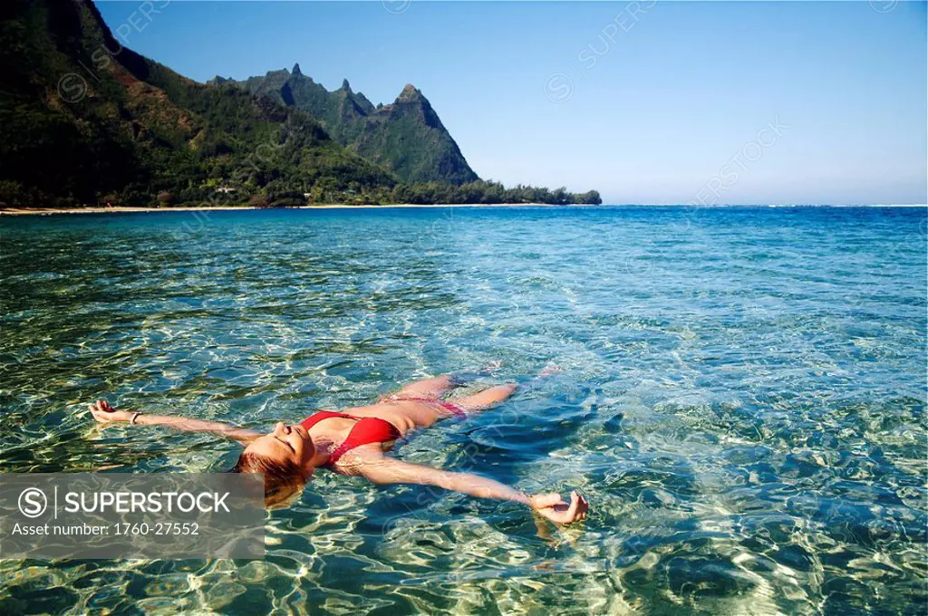Hawaii, Kauai, Tunnel´s beach, Woman floats in the ocean.