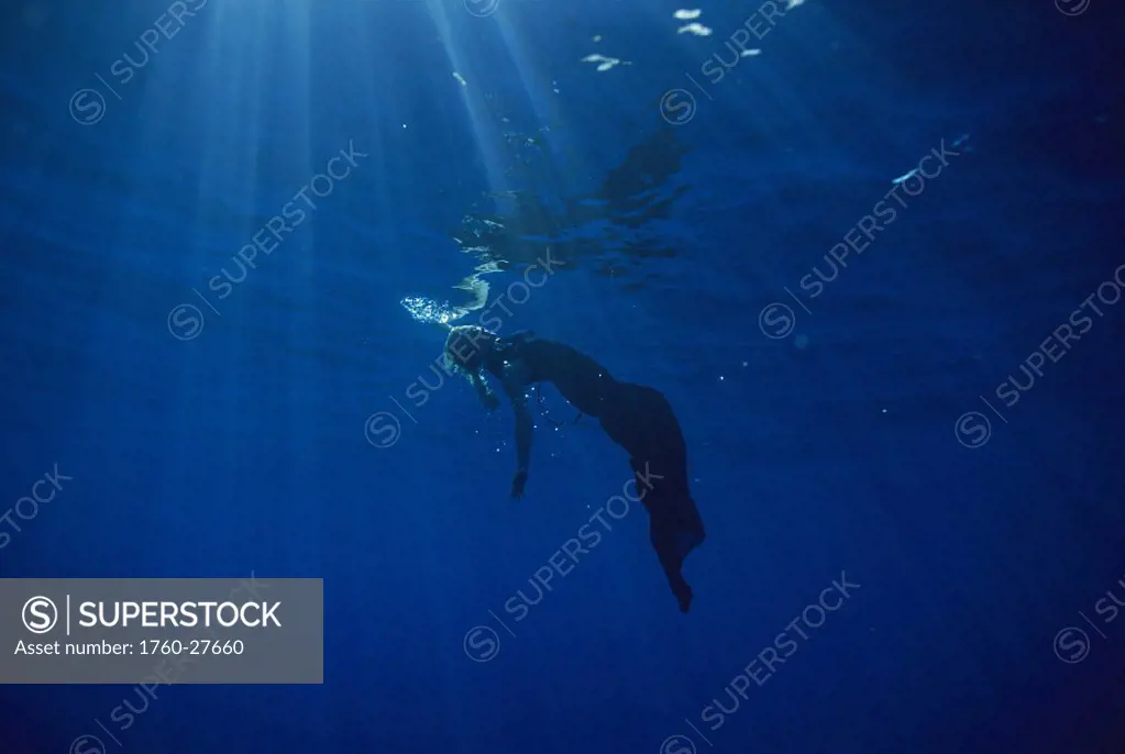 Abstract full length view of woman evening gown underwater surface & sunrays surreal