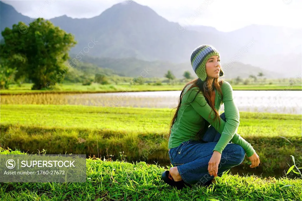 Hawaii, Kauai, Hanalei, Beautiful fashion model 0n a grassy field.