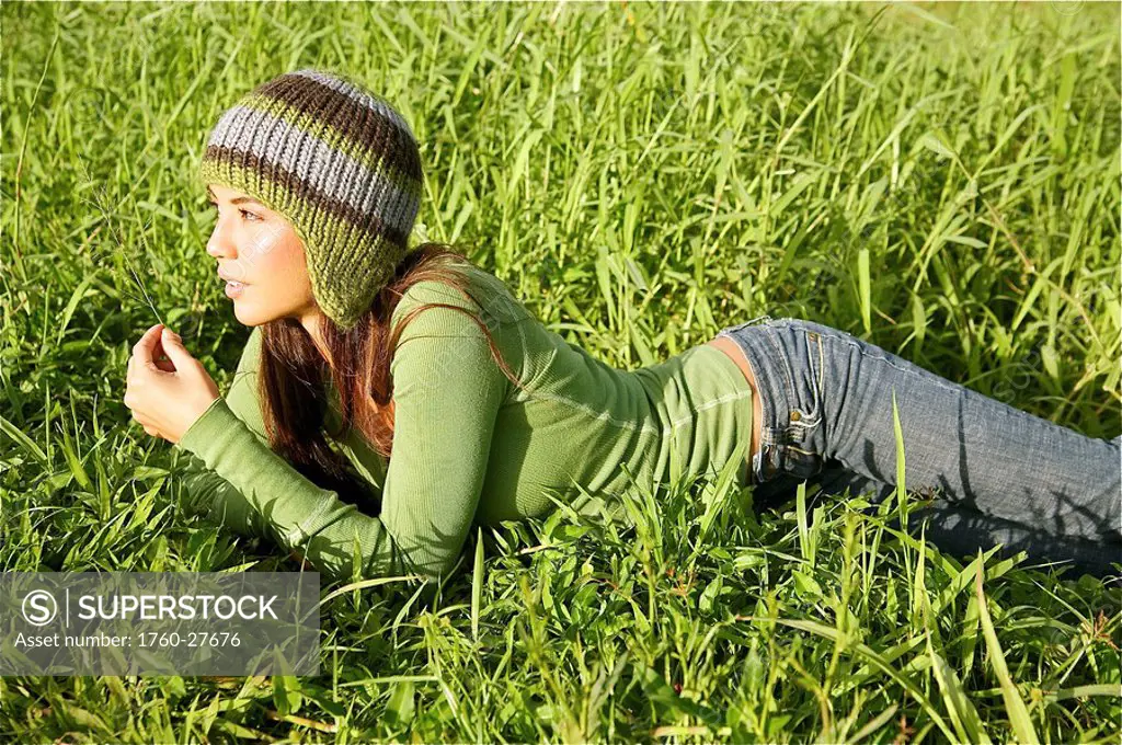 Hawaii, Kauai, Hanalei, Beautiful fashion model 0n a grassy field.