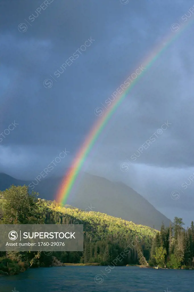 Alaska, view of rainbow over Kenai river, hazy day, mountains in background