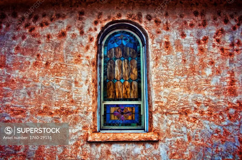 New Mexico, Adobe church wall with stained_glass window.