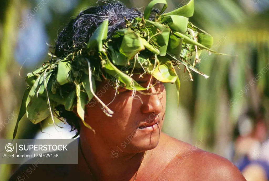 Cook Islands, headshot of local man wearing ti-leaf haku, head turned to side