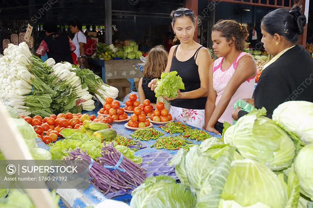 Fiji, Viti Levu, Sigatoka, Female tourist buying produce at a market