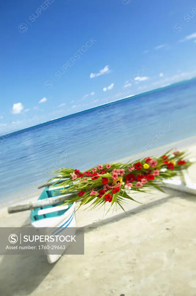 French Polynesia, Huahine, Outrigger canoe on the shore of a tropical beach, decorated with beautiful flowers for a wedding