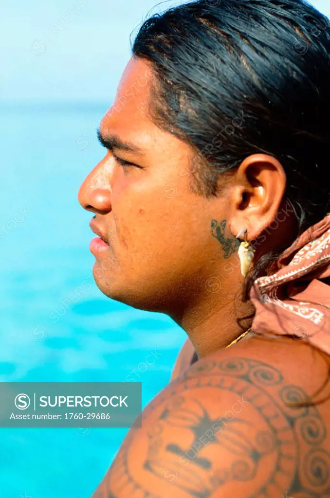 French Polynesia, Tahiti, Huahine,Tahitian man with tattoos, view from side