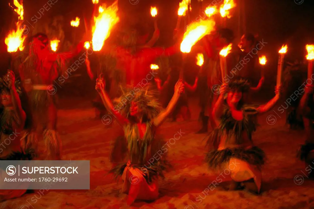 Tahiti, Moorea, female fire dancers perform at night, red hue, flames held high