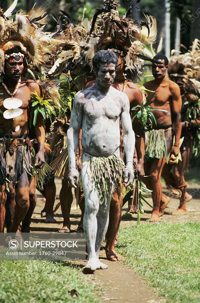 Papua New Guinea, Highlands village, Initiation ceremony, man covered in white body paint, walking in line of natives