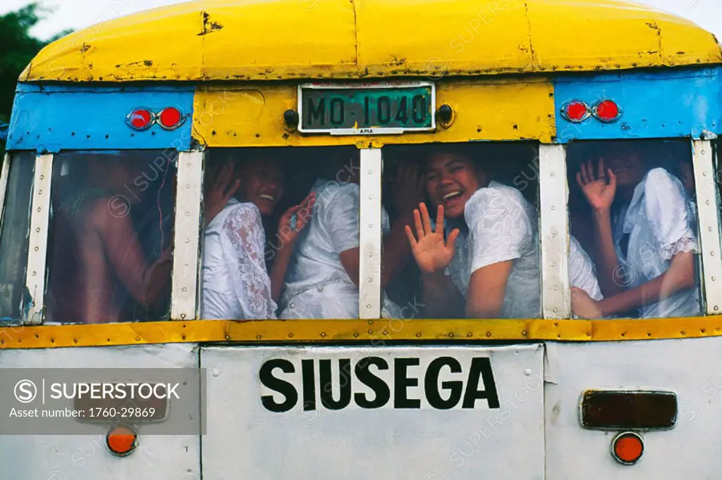 Western Samoa, Apia, Suisega, Samoan children all crowded into the back of bus smiling and waving.
