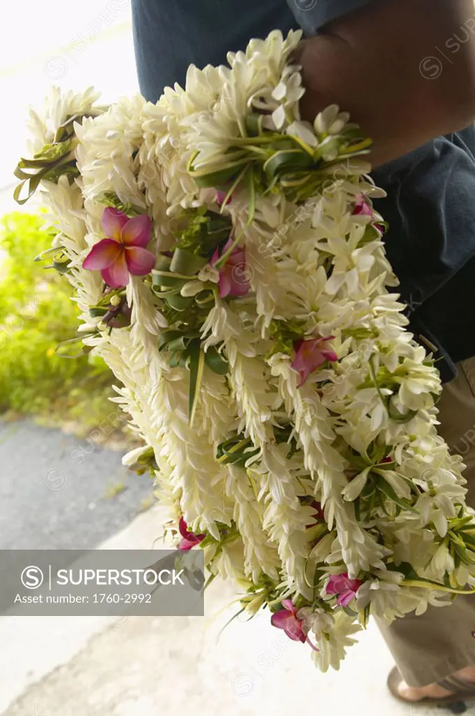 French Polynesia, Tuamotu, Close-up of many leis hanging on a mans arm at the airport