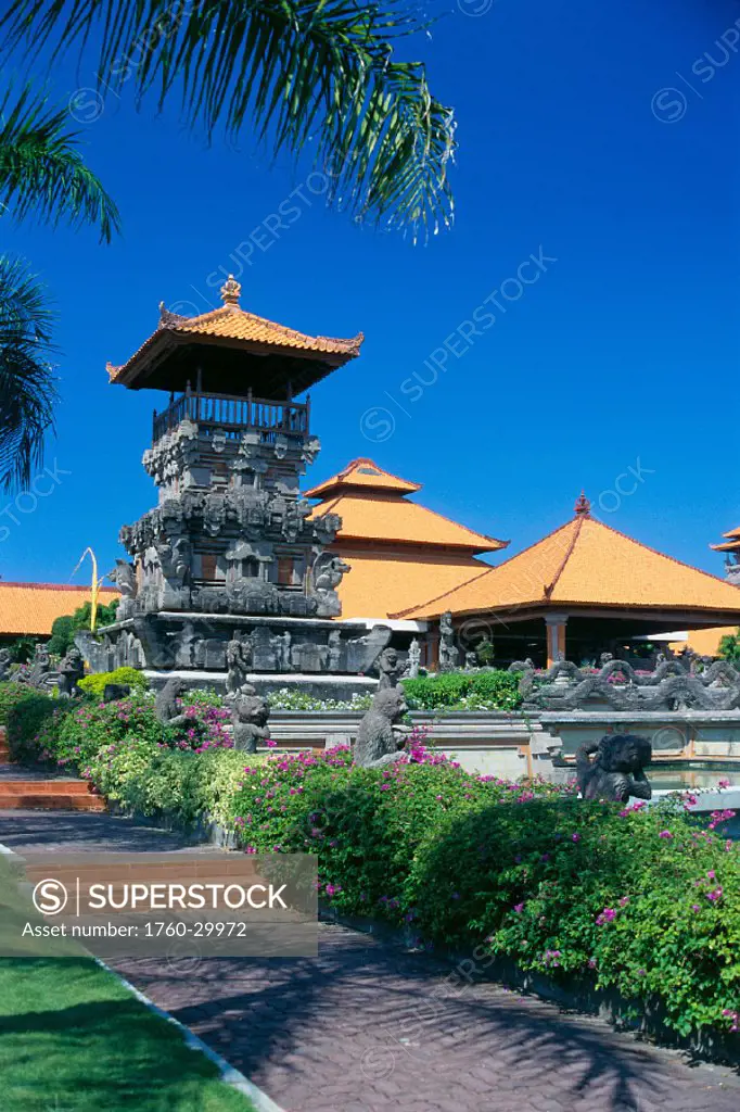 INDO, Bali, Nusa Dua, Hilton Hotel courtyard w/ statues, flowers, blue sky