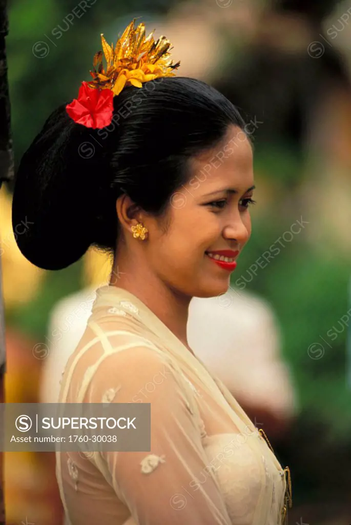 Indonesia, Bali, Local woman wearing traditional ceremonial dress, smiling, view from side ´NO MODEL RELEASE´