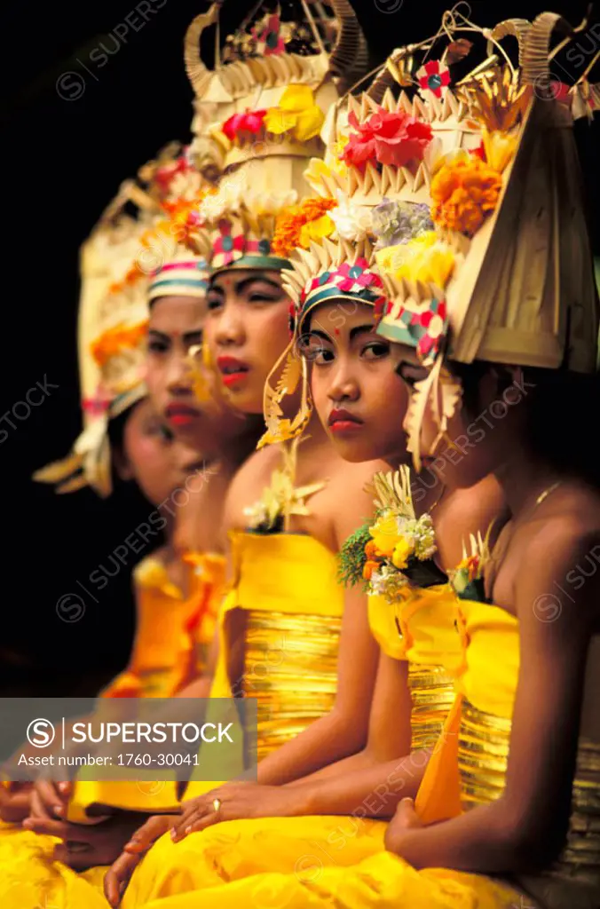 Indonesia, Bali, group of young girls in ceremony sitting in row in colorful costume and headdress ´NO MODEL RELEASE´