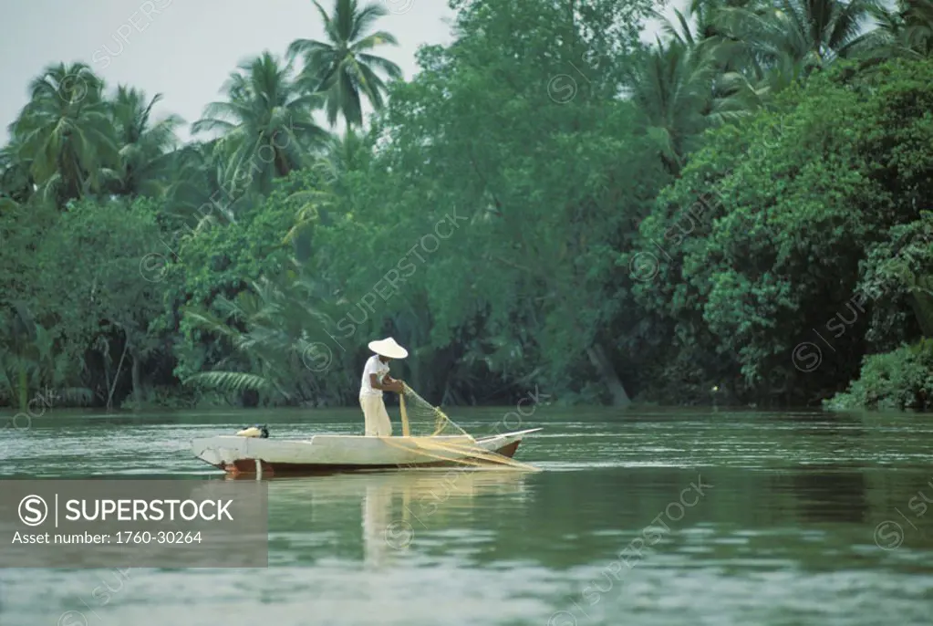 Malaysia, Kuching Sarawak, Local wearing conical hat fishing in Sarawak River NO MODEL RELEASE