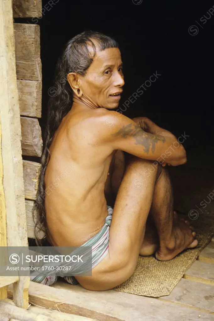 Malaysia, Sarawak near Kuching, Dayak man sits in doorway