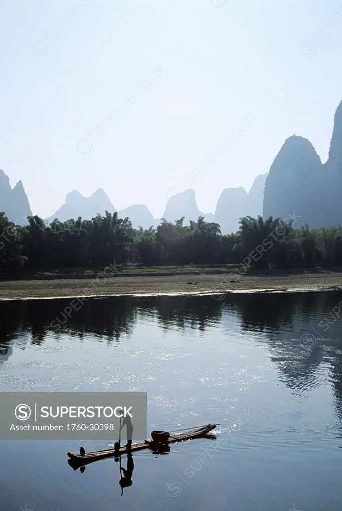 China, Li River, near Yangshou, Local man floating on bamboo raft