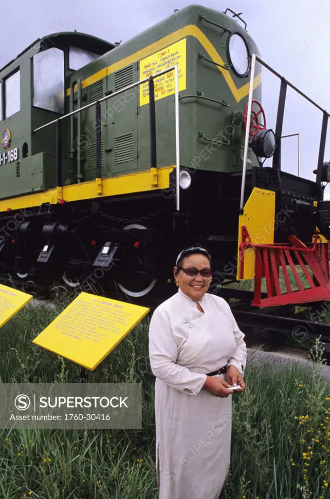 Mongolia, Retired train museum, Trans-Siberian Railroad, Woman caretaker in front of trains.