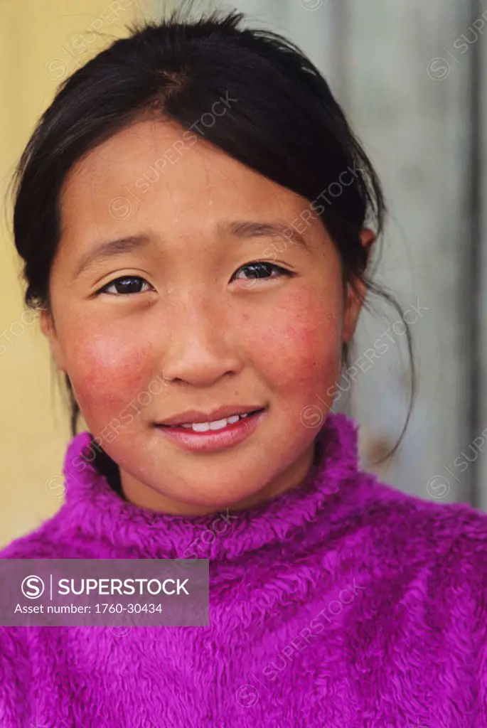 Mongolia, Ulaanbaatar, Headshot of young local girl in purple sweater.