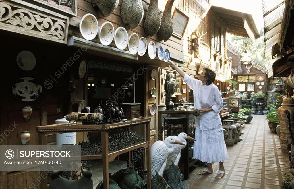 Thailand, Chiang Mai, Antique outdoor shopping mall, Woman looking at items for sale