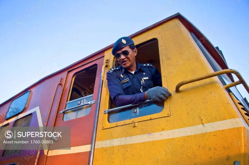 Thailand, Kanchanaburi, WW2´s infamous Death Railway, The engineer of a Thai passenger train looks down as he talk to the railroad bridge guard.