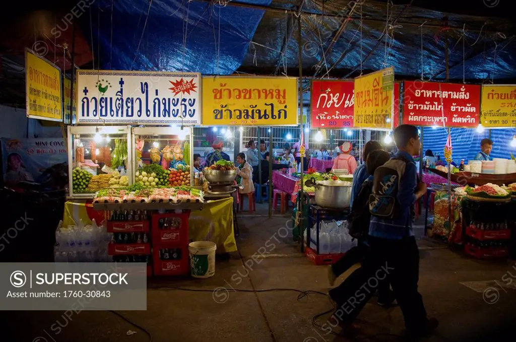 Thailand, Khon Kaen, Passersby walk past the entrance to an annual Silk Festival.
