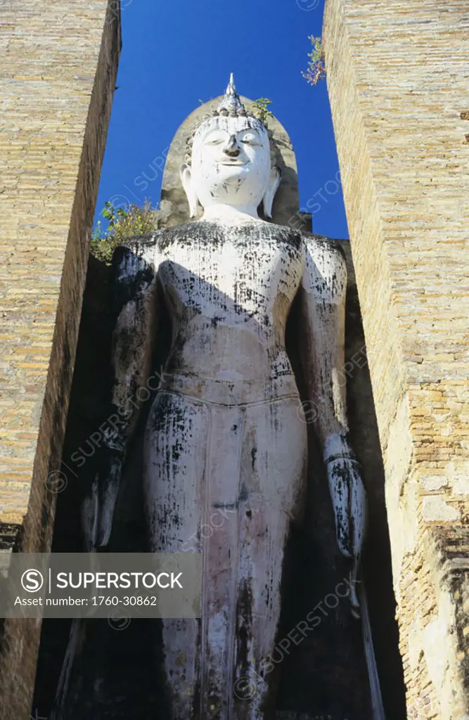 Thailand, Sukhothai, Wat Mahathat, full length standing stone statue between pillars