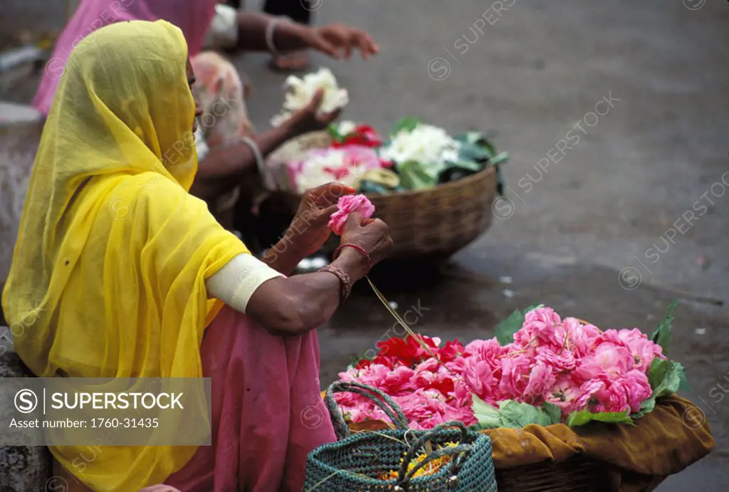 India, Udaipur, Local flower endor sits on street stringing flower garland NO MODEL RELEASE