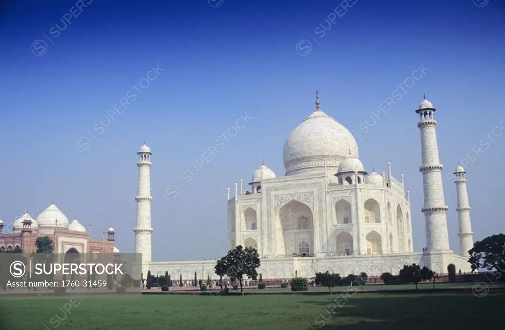 India, Agra, Taj Mahal, green grass and blue sky, angled view from front.