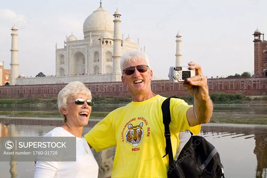 India, Agra, tourist couple taking photo of themselves in front of the Taj Mahal