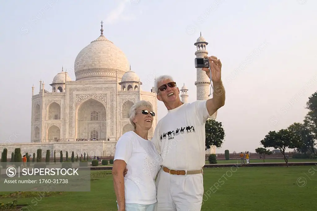India, Agra, tourist couple taking photo of themselves in front of the Taj Mahal