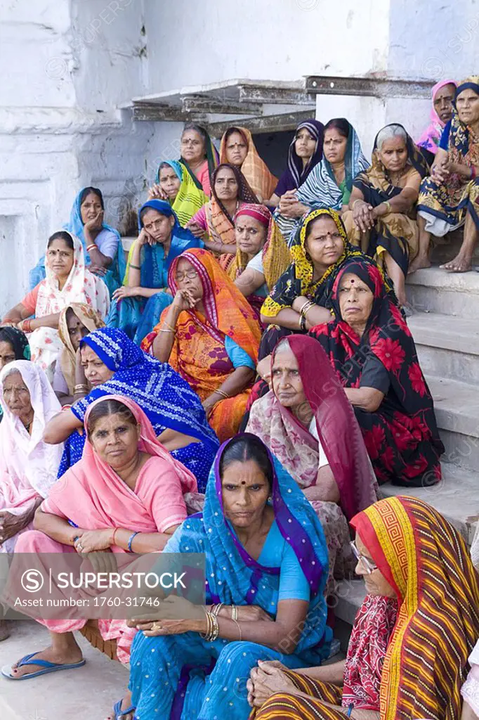 India, Mathura, group of Hindu women in colorful sari and veils sitting on steps