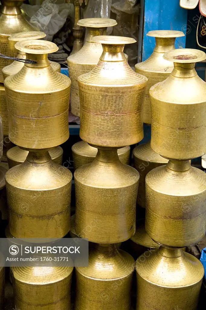 Nepal, Kathmandu, Stack of shiny brass pots in Durbar Square