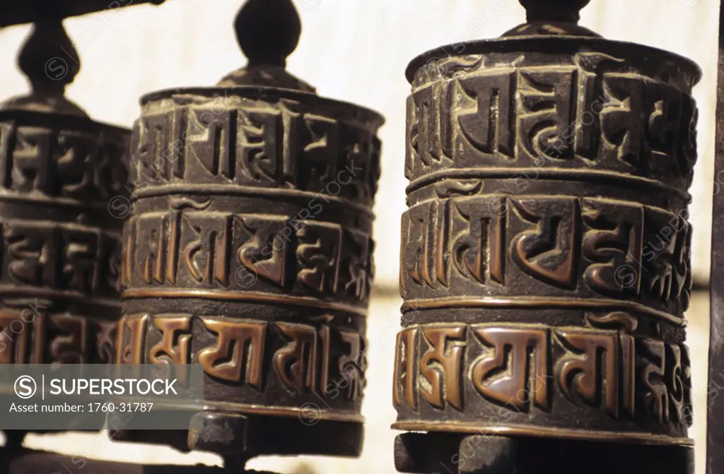 Nepal, Kathmandu, Swayambhunath Temple, closeup of prayer wheels with carvings.