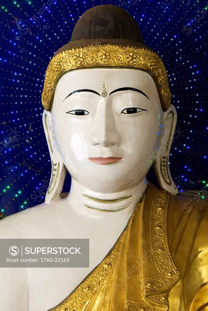 Myanmar, Yangon, Shwedagon, Paya, Head Of A Buddha Statue Against Blue Background.