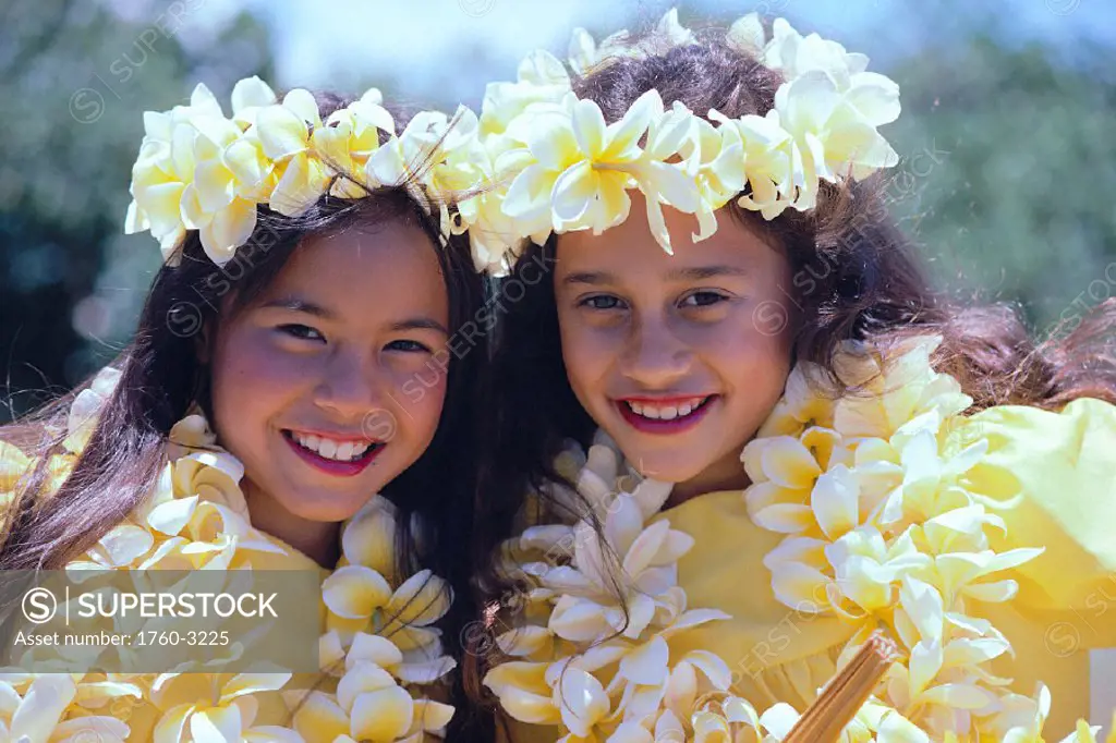 Hawaii, Two smiling hula girls, both wearing yellow plumeria lei C1439