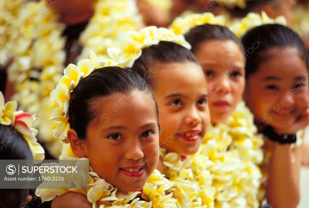 Hawaii, Smiling girls wait to dance hula, yellow plumeria lei
