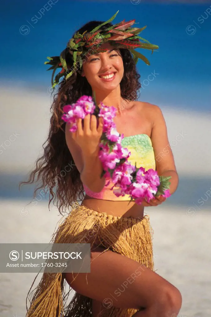 Hawaii, Beautiful Polynesian woman kneeling offers lei
