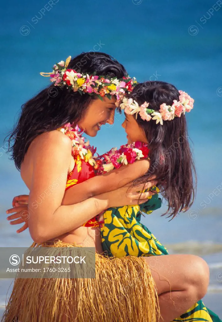 Close-up of mom with daughter in lap, heads together, smiling, hula oufits