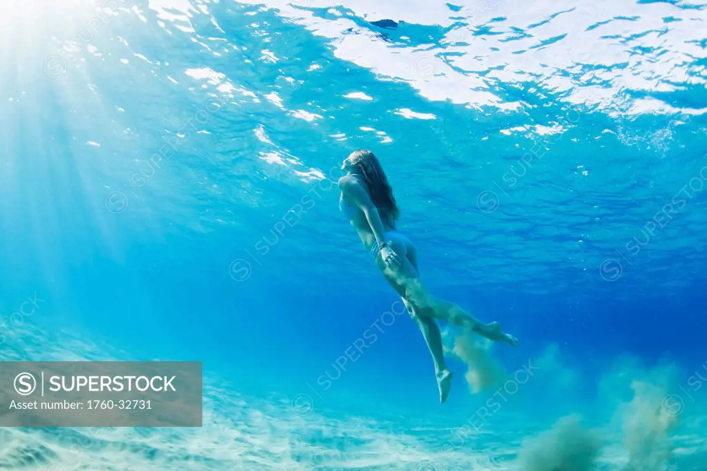Hawaii, Maui, Makena, Young Woman Swimming To Ocean Surface, Dropping Sand As She Goes.