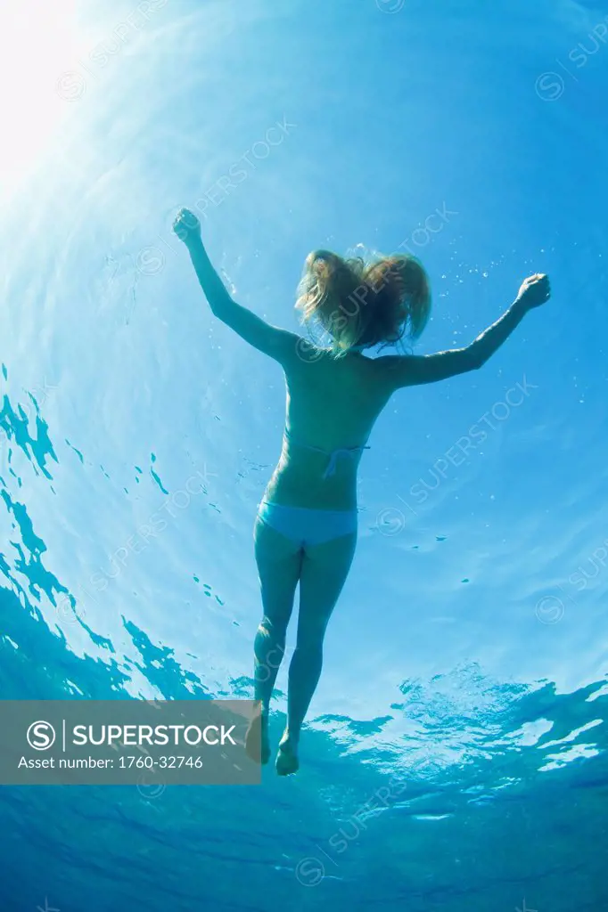 Hawaii, Maui, Makena, Young Woman Enjoys Floating In The Ocean.