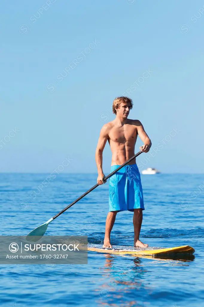Hawaii, Maui, Kihei, Young Man Stand Up Paddling In The Ocean On Sunny Day.