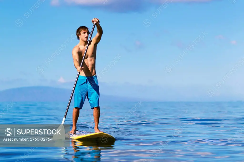 Hawaii, Maui, Kihei, Young Man Stand Up Paddling In The Ocean On Sunny Day.