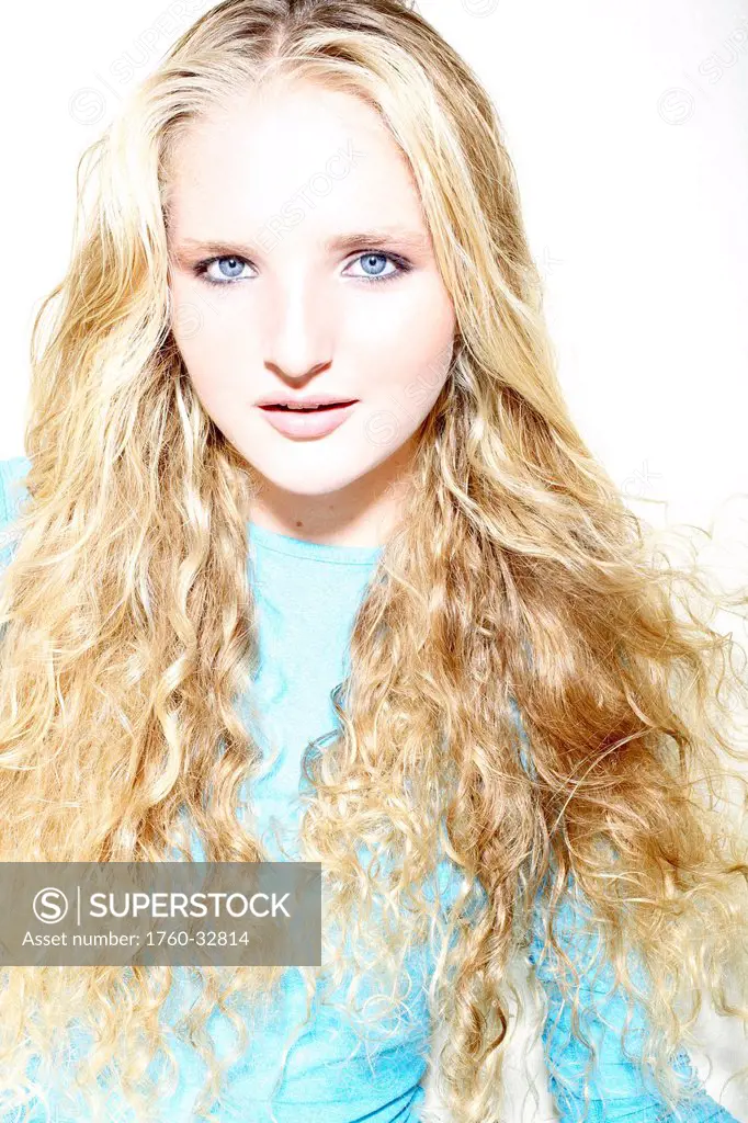 Attractive Woman With Long Curly Blonde Hair Poses In Studio.