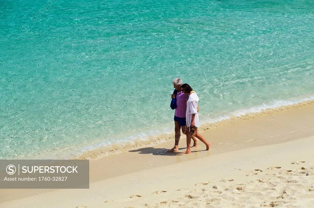 Caribbean, Barbados, Senior Couple Walking Along Beach, Clear Turquoise Ocean Water.