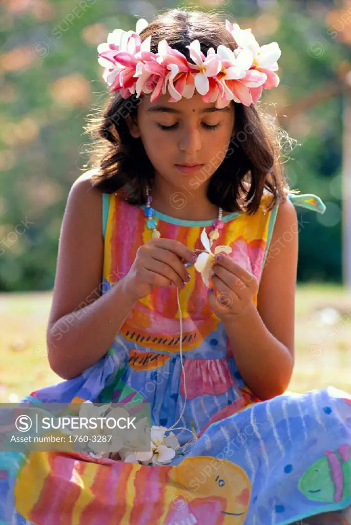 HI, closeup front view of young girl wearing haku lei, stringing plumeria C1474 flowers