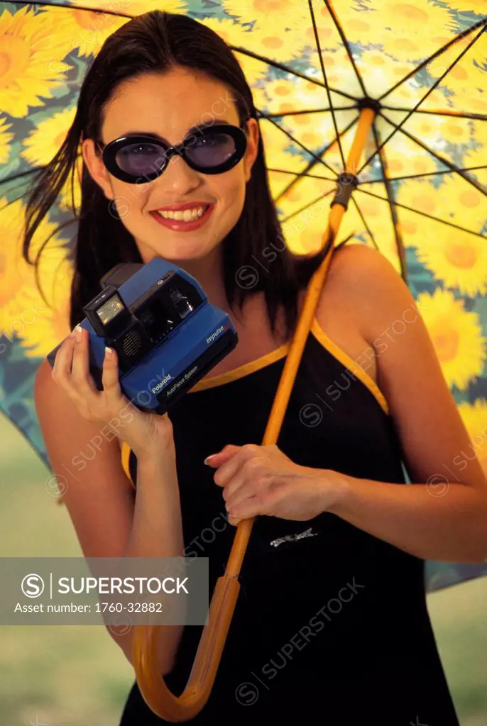 Close-Up Portrait Of Woman With Sunglasses Holding Sunflower Umbrella, Polaroid Camera