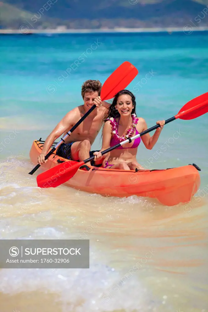 Hawaii, A Young Couple Paddling Their Kayak.