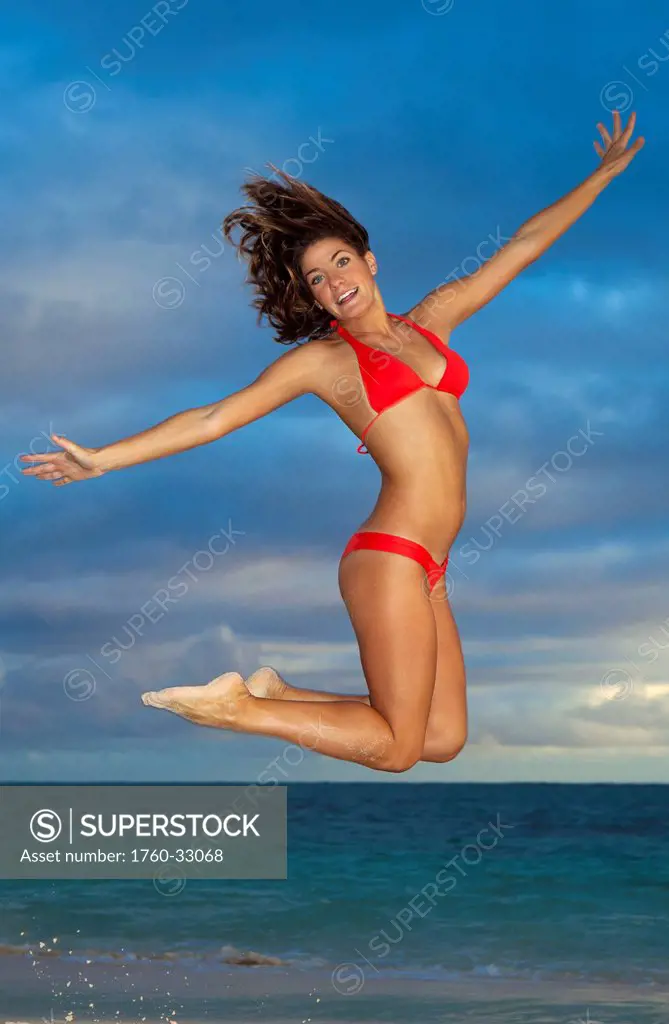Hawaii, Oahu, Young Woman Jumps For Joy On The Beach.