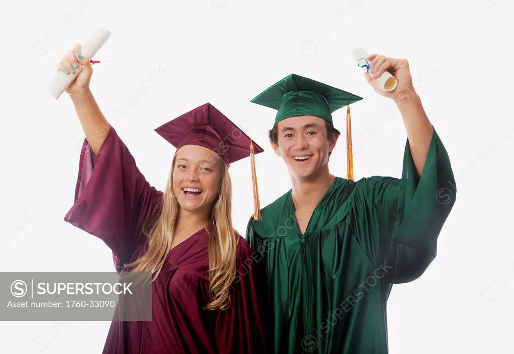 Male And Female Graduates In Cap And Gown, Holding Diplomas.